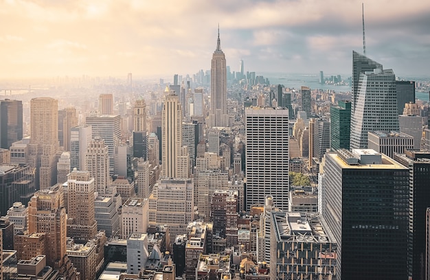 Iconische luchtfoto van New York City op een zonnige dag. Zonnestralen tussen de wolkenkrabbers en bewolkte achtergrond. Concept van reizen. NYC, VS.