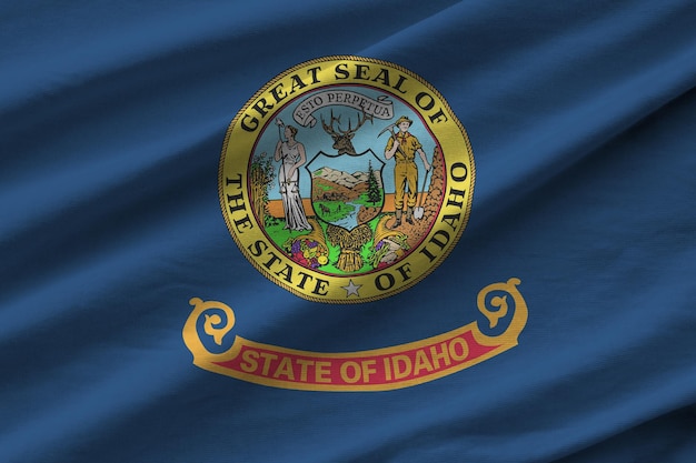 Фото Айдахо государственный флаг сша с большими складками, развевающимися крупным планом под студийным светом в помещении официальные символы и цвета на баннере
