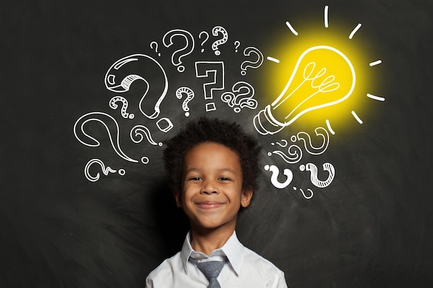 Photo idea concept black boy student with lightbulb on blackboard background