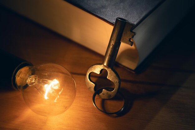 Idea concept,key with lightbulb and book on table