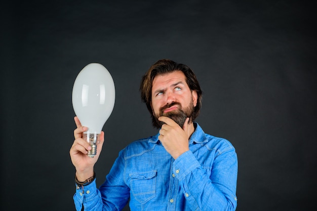 Idea concept lamp in hand good idea pensive man with light bulb birth of ideas surprised man with