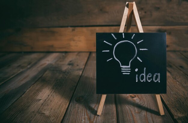 Idea concept Light bulb drawn on a chalkboard dark wooden background