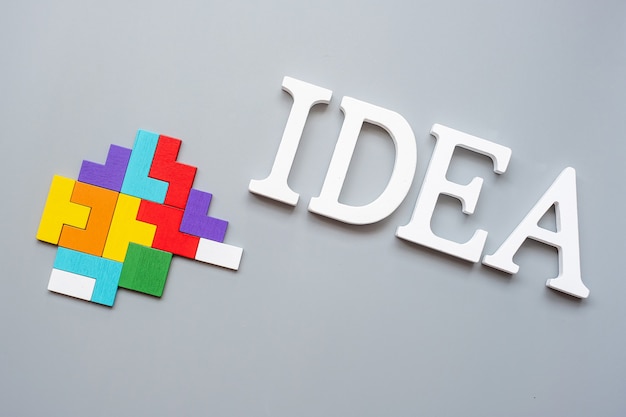 Idea text with colorful wood puzzle pieces on gray . logical thinking, business logic, conundrum, inspiration, solutions, rational, mission, success, goals and strategy concepts