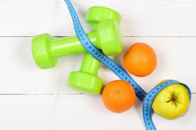 Ideaal maatconcept dumbbells gewicht met meetlint fruit