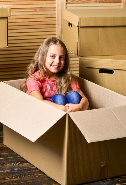 방의 이상적인 장소 수리 새 아파트 새 거주지 구입 골판지 상자 새 집으로 이사 행복한 아이 판지 상자 곰 장난감을 가진 행복한 어린 소녀