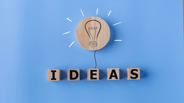 写真 青い背景の電球と木製のキューブのアイデアコンセプト クリエイティブな思考アイデアとイノベーションコンセプト