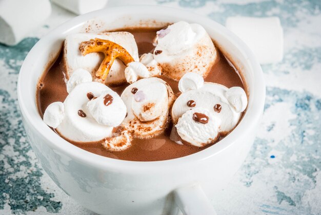 Idee voor een kerstsnack voor kinderen, warme chocolademelk met teddyberen en herten marshmallow. kopieer de ruimte op een lichte ondergrond