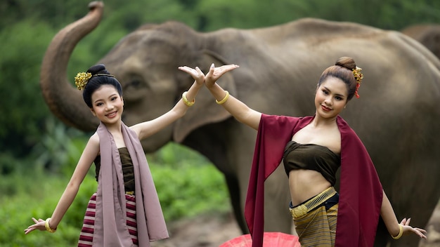 Identiteitscultuur van Thailand Twee Thaise vrouw in traditionele Thaise cultuurkostuum met Thaise olifant Mooie Aziatische vrouw draagt traditionele Thaise kleding en olifant