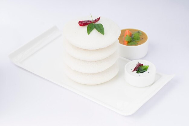 Idly or Idli south indian main breakfast item garnished with red dry chilli and curry leaves