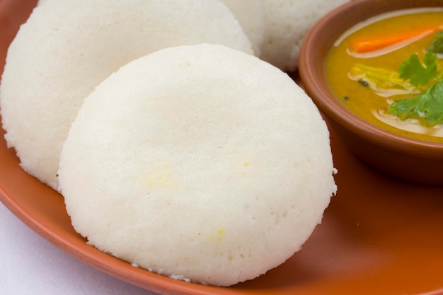 Idly или Idli южно-индийское основное блюдо для завтрака, красиво уложенное в глиняной посуде.