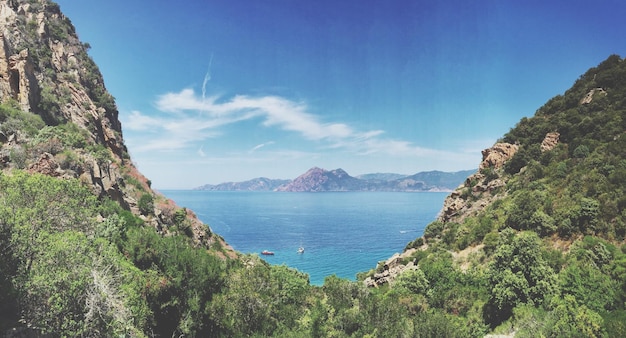 idyllic shot of sea and mountains against sky