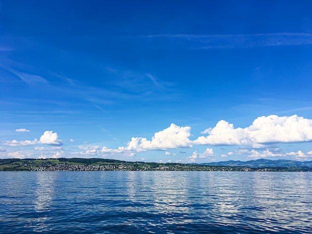 リヒタースヴィルスイスの山々にあるチューリッヒ湖の牧歌的なスイスの風景ビュー夏の自然としてのチューリッヒ湖の青い海と風光明媚なアートプリントとして理想的な旅行先