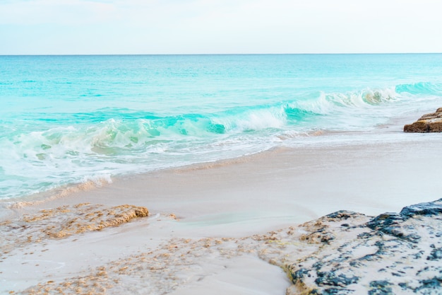 Idyllic tropical beach with white sand, turquoise ocean water and blue sky on Caribbean island