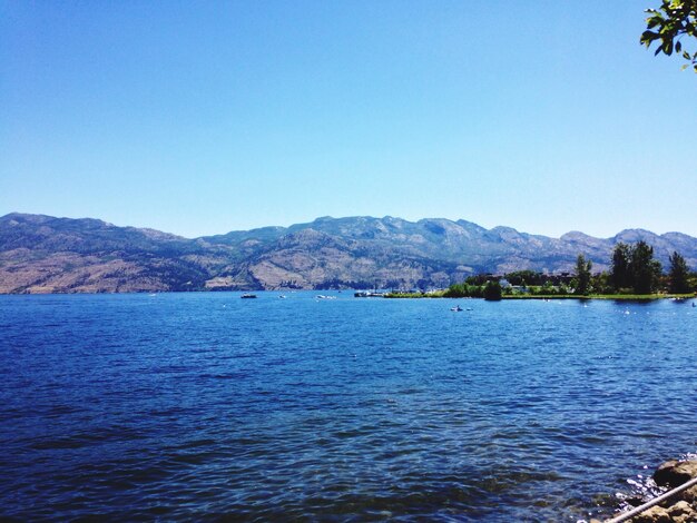 Idyllic view of lake and mountains against clear sky