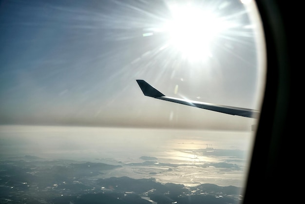 写真 飛行機の窓から見た海上の太陽の理想的な景色