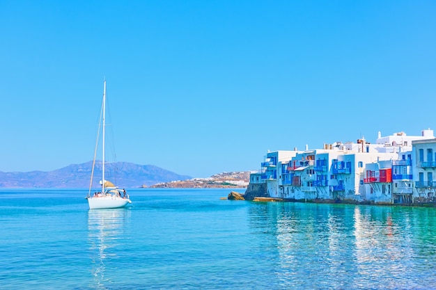 Idyllisch Grieks landschap met huizen aan zee op het eiland Mykonos en zeiljacht, Griekenland