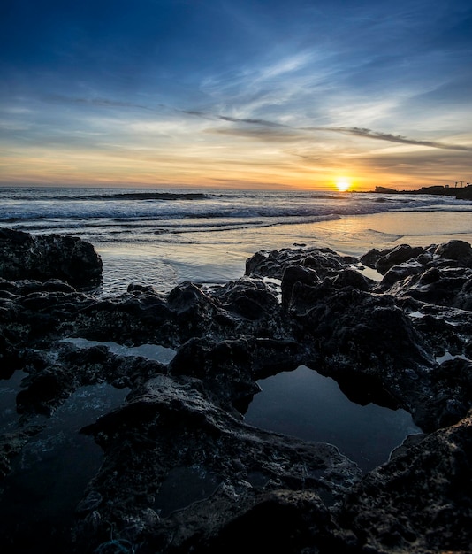Idyllisch uitzicht op het strand tegen de hemel bij zonsondergang