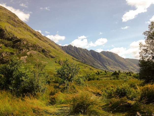 Idyllische opname van een groen landschap met bergen tegen de lucht