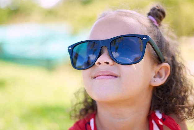 Iedereen houdt van zonnige dagen Foto van een schattig klein meisje met een zonnebril in het park