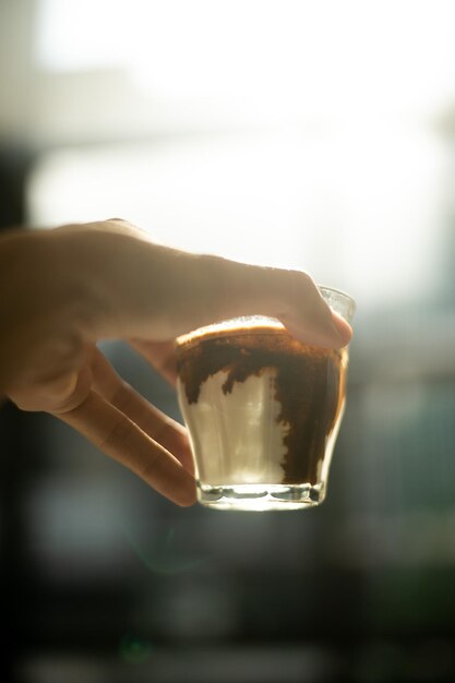 Iemand houdt een glas chocoladewater in de hand.