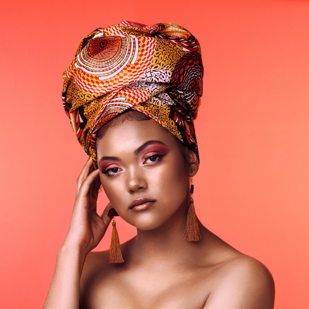 Photo if the crown fits wear it studio shot of an attractive young woman wearing a traditional african head wrap posing against an orange background