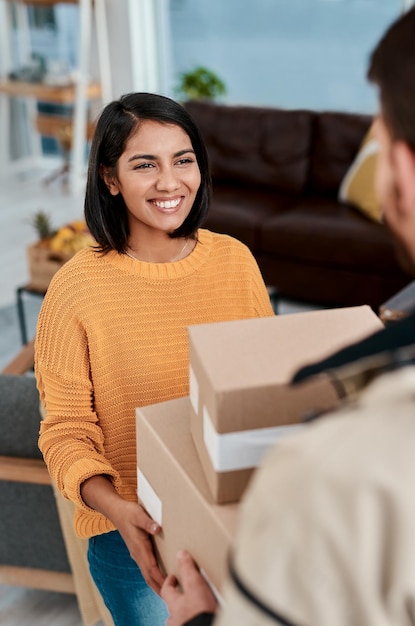 If theyre smiling they did a good job Shot of a young woman receiving a package from a delivery man at home