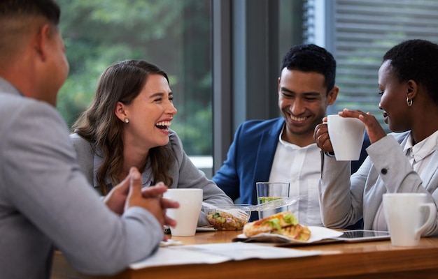 If you can laugh together you can work together Shot of a group of colleagues having a meeting and breakfast in a modern office