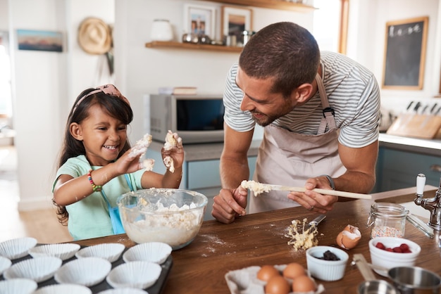 Se non ti sporchi le mani non è divertente inquadratura ritagliata di un giovane che cucina a casa con la sua giovane figlia