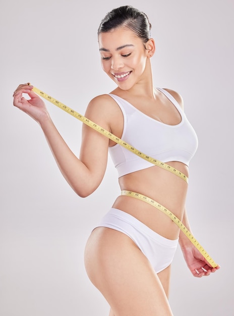 If youre feeling good on the inside youre looking great on the outside Studio shot of a fit young woman holding a measuring tape around her waist