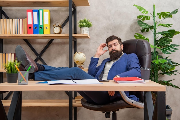 あなたが疲れているなら休むことを学ぶ疲れたビジネスマンは机の椅子でリラックスするオフィスで休憩する