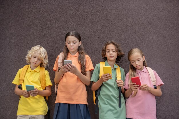 Igen. Four kids playing online games on their smartphones