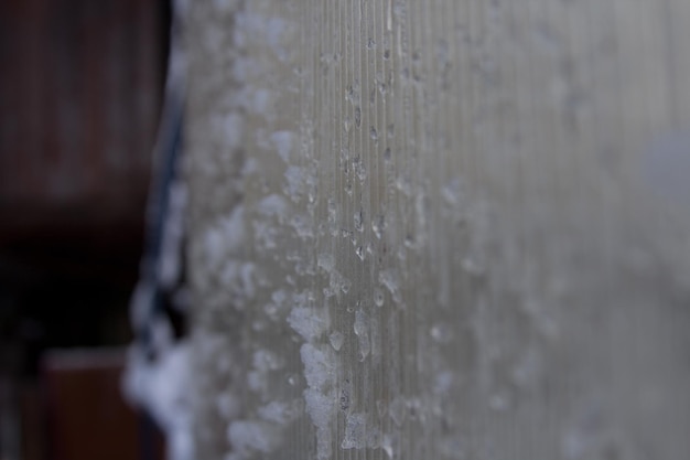 IJs en sneeuw op de glazen wand van het huis