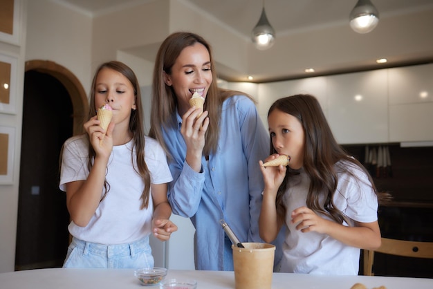 IJs eten Gelukkige Aziatische familie die thuis ijs eet Mooi kind dat moeder voedt