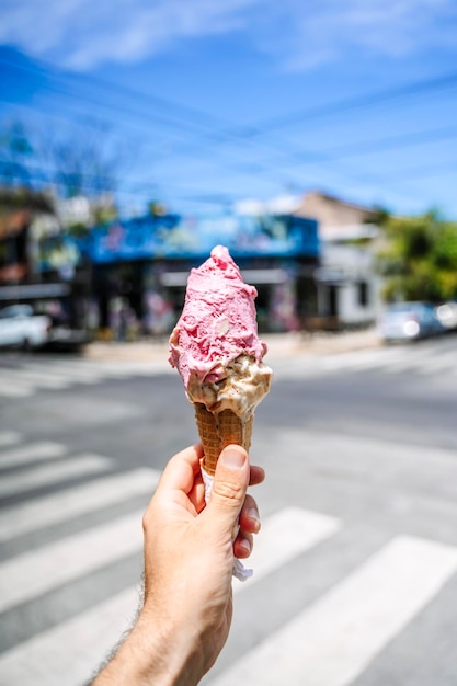 IJs in de hand wafelkegel met ijs op de achtergrond van de straat in de zomer op een hete