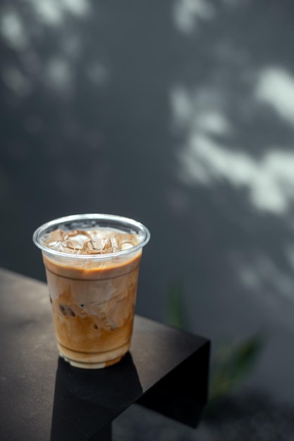 IJs latte koffie in plastic glas op zwarte tafel in café