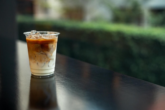 IJs latte koffie in plastic glas op zwarte tafel in café