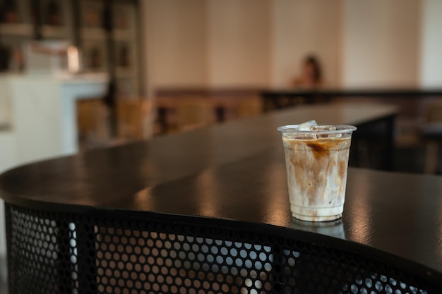 IJs latte koffie in plastic glas op zwarte tafel in café