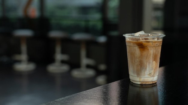 ijs latte koffie in plastic glas op zwarte tafel in een café