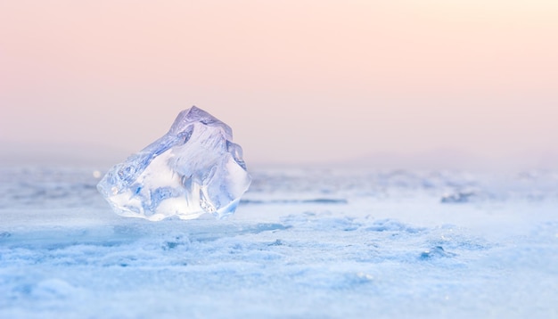 Ijs op het bevroren meer bij zonsondergang. Ondiepe scherptediepte. Mooie winterse achtergrond