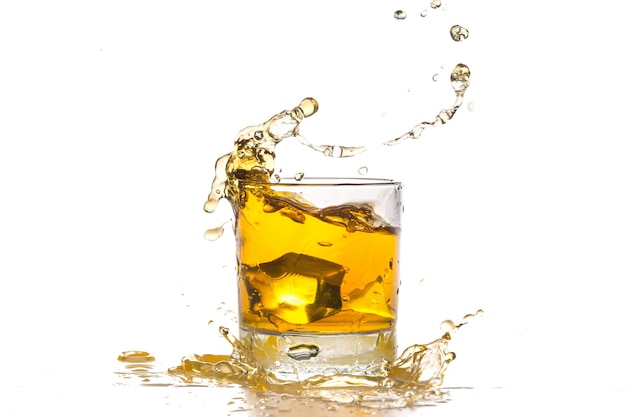 Ijsblokje dat in whisky in glas valt