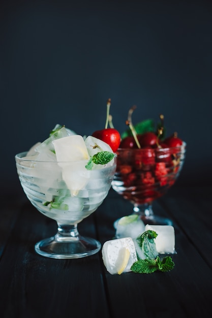 IJsblokjes met fruit en kersen op zwarte achtergrond