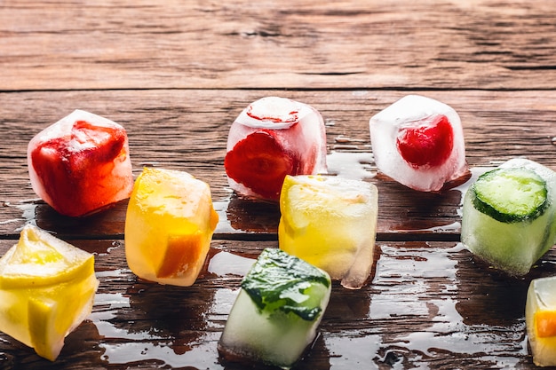 Foto ijsblokjes met fruit op houten tafel. hete zomer concept, dessert