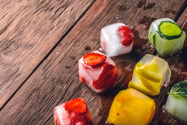 Foto ijsblokjes met fruit op houten tafel. hete zomer concept, dessert