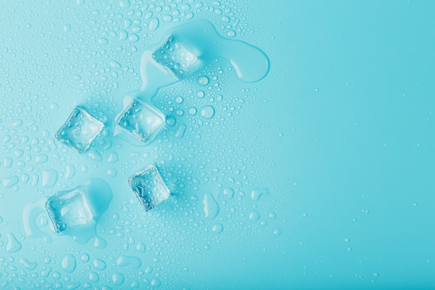 Foto ijsblokjes met waterdruppels verspreid, bovenaanzicht.