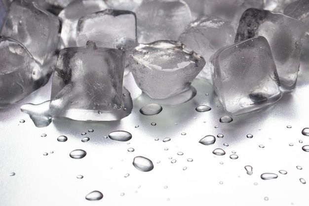 IJsblokjes op een reflecterende tafel met druppels water