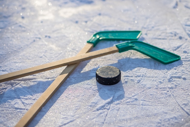 ijshockeystick met witte tape en puck. teamspel, concurrentieconcept in het bedrijfsleven. IJshockeysticks en puck