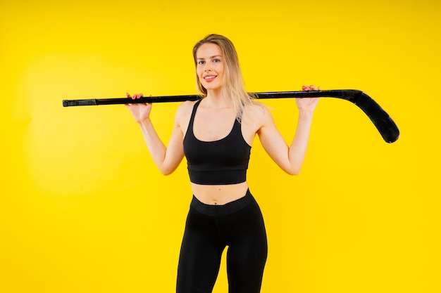 IJshokkie-fan vrouw in sportkleding met hockeystok in de studio