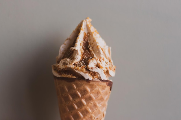 IJshoorntje op muurachtergrond Karamelroomijs met wafel Zomerdessert IJs close-up