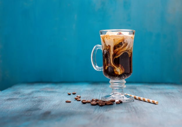 IJskoffie in een glas op blauwe achtergrondexemplaarruimte