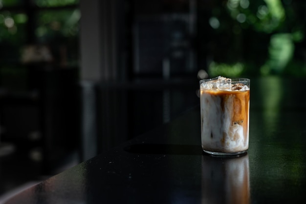 IJskoffie in een glas op tafel in een koffiewinkel. Onduidelijke achtergrond.